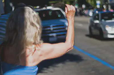 blond woman in blue shirt appears to wait for ride