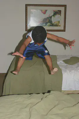boy is jumping on bed